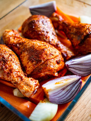Marinated raw chicken drumsticks ready to roast