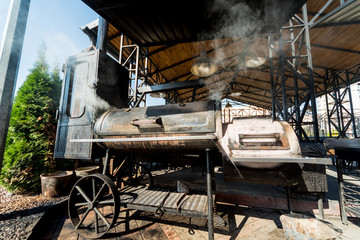 Large barbecue smoker grill at the park. Meat prepared in barbecue smoker.