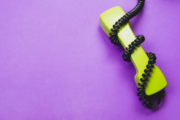 Retro telephone handset. phone receiver isolated on purple background. old communication technology
