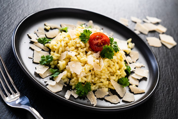 Risotto with parmesan on black stone plate