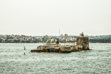 Brick island with small lighthouse floating on the water