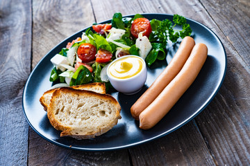 Continental breakfast - boiled sausages, toasts and greek salad
