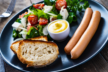 Continental breakfast - boiled sausages, toasts and greek salad