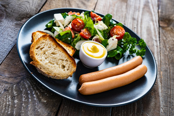 Continental breakfast - boiled sausages, toasts and greek salad