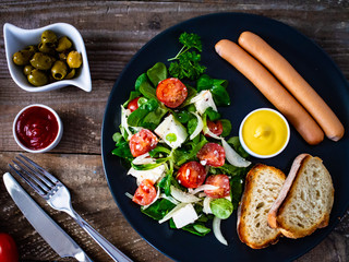 Continental breakfast - boiled sausages, toasts and greek salad