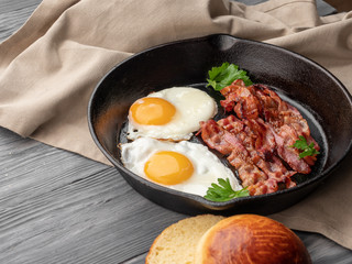 Fried eggs with bacon in a pan.