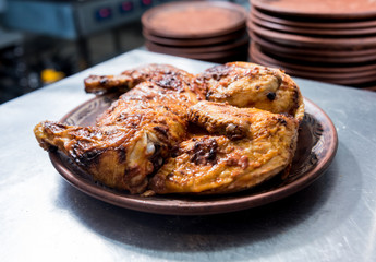 Rroasted chicken with olive oil on the kitchen table. Restaurant.