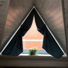 triangular window with a flowerpot on a white wood background