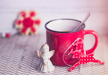 Red mug on a light background and ceramic figurine
