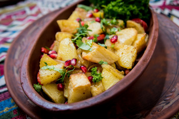 Fried potatoes with pieces of meat in a clay pot. European cuisine.