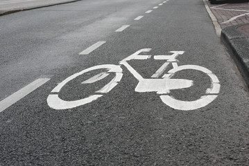 Obraz premium Sign bike path on the asphalt roadway of the road in the city. Symbol to indicate the road for bicycles.Soft-focus