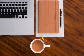 Horizontal Alignment Layflat of workspace. Self starter, meeting minutes, note taking and working as a student or at a cafe/ coffee shop on wooden table with cup of coffee/tea