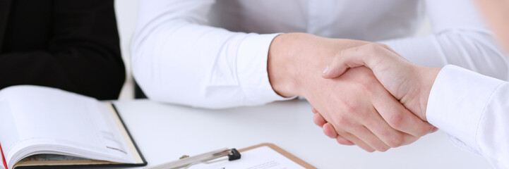Partnership agreement closeup with man in suit shake hand as hello in background. Friend welcome...