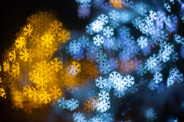 Blurred lights in the snowflake shape with bokeh. Abstract New Year and Christmas  Background.