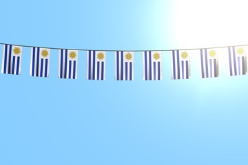 cute celebration flag 3d illustration. - many Uruguay flags or banners hanging on rope on blue sky background