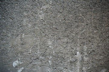 Texture of an old cracked concrete wall. Background image of a worn gray concrete surface