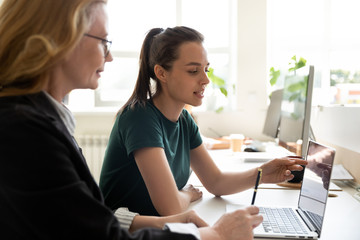 More experienced employee helping with corporate app to older teammate