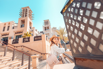 Happy Asian tourist girl walks through the old Arab city in Dubai, United Arab Emirates