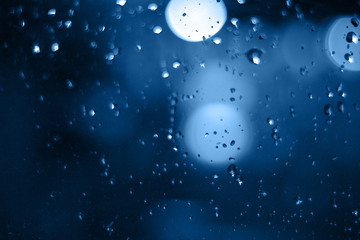 Rain drops on window with bokeh on blure background