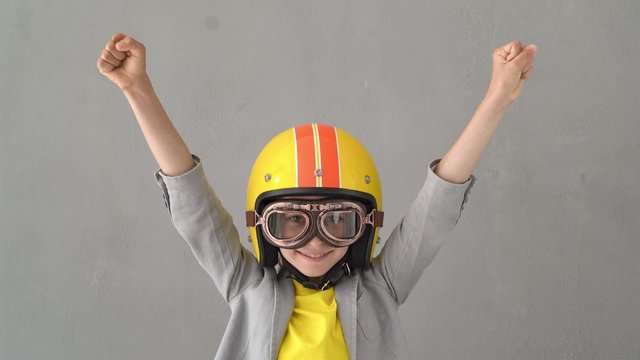 Happy child wearing racing helmet and goggles. 4K