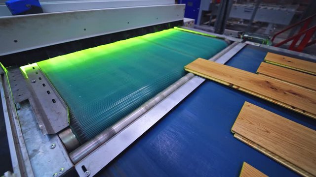 Interior of furniture factory. Production line of parquet board. Modern industrial factory for laminated flooring.