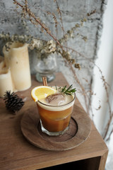 Nitro Orange Cold Brew garnish with rosemary on wooden table