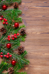 Christmas background with xmas tree and red berries on  wooden background. Merry christmas greeting card, frame, banner. Winter holiday theme. Happy New Year. Space for text.