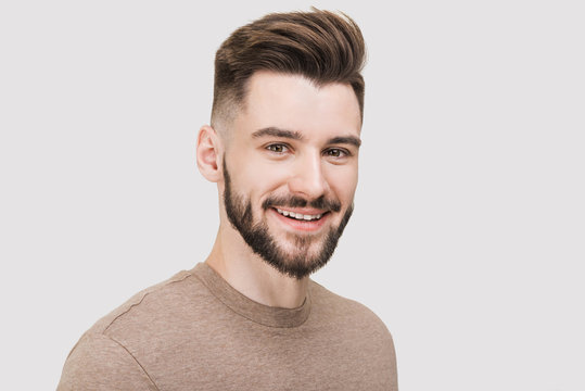 Closeup portrait of handsome smiling young man. Laughing joyful cheerful men studio shot. Isolated on gray background