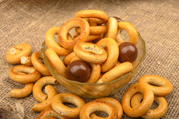 Small bagels, brown sugar and ceramic dishes on a wooden background close-up.