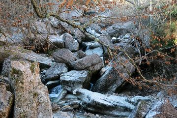 Un río de montaña con grandes piedras en invierno