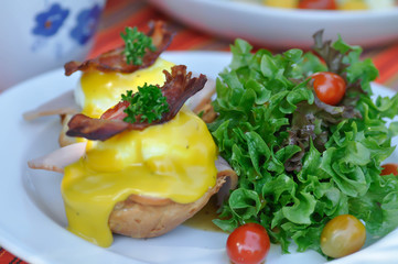 egg benedict or bun with egg , ham and bacon