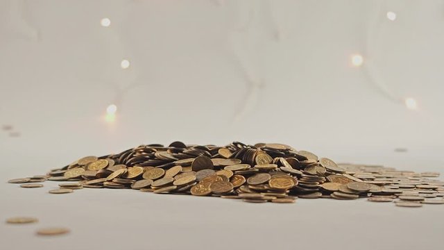 White-gloved hands scooping up a pile of gold coins. They sort out and scatter money.On white background. Garland. Money glitters.