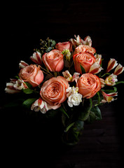 dark luxurious bouquet of gorgeous pink roses for Valentine's day on a dark wood background