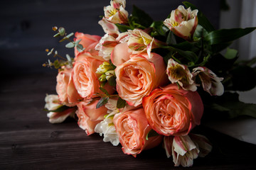 dark luxurious bouquet of gorgeous pink roses for Valentine's day on a dark wood background