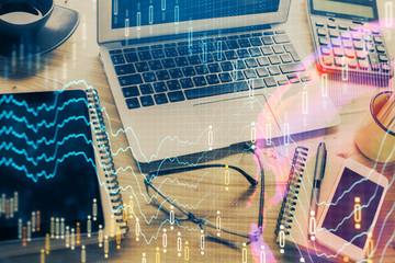 Financial graph colorful drawing and table with computer on background. Double exposure. Concept of international markets.
