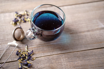 Pea tea, butterfly blue tea in glass mug, herbal detox drink. Anchan. Herbal hot or cold beverage on old wooden table