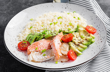 Healthy meal.  Salad with salmon, couscous, avocado and tomatoes.  Eastern oriental lunch