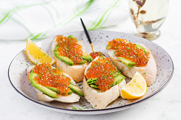 Sandwiches with salmon red caviar with sliced avocado. Sandwich for lunch. Premium food.