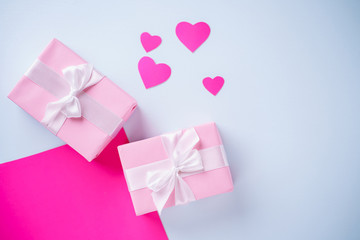 Holiday design template with festive gift box wrapped with ribbons. Multicolored background studded with hearts, copy space. Birthday, Valentines, mother's day, celebration concept