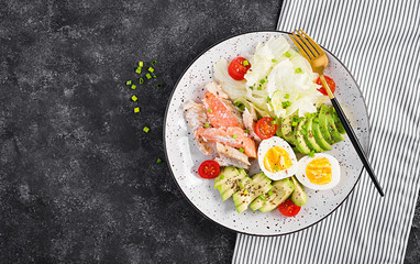 Ketogenic diet breakfast. Eggs, fish and avocado, lettuce and seeds. Low carb high fat breakfast. Keto/paleo menu. Top view, flat lay