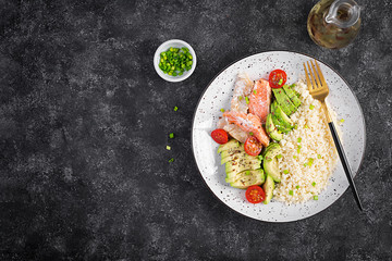 Healthy meal.  Salad with salmon, couscous, avocado and tomatoes. Top view, copy space, overhead. Eastern oriental lunch