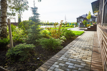 Obraz premium Landscaping of the garden. The path in the garden near the cottage