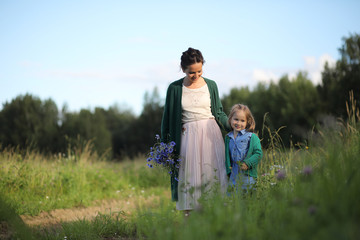 Fototapeta premium Mother with daughter walking on a road