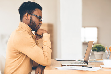 Black guy working on his laptop at home