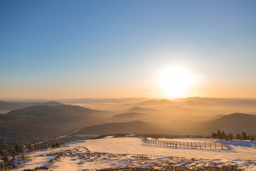 Winter landscape in Sheregesh. Frozen snow on trees. Frozen trees on a background of blue cloudy sky. A lot of snow fell in the winter cold in the mountains. Sunrise in the mountains