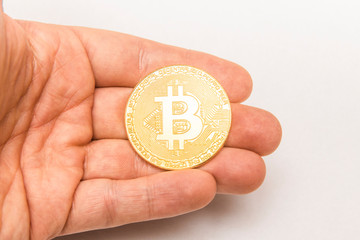 A Bitcoin in a hand