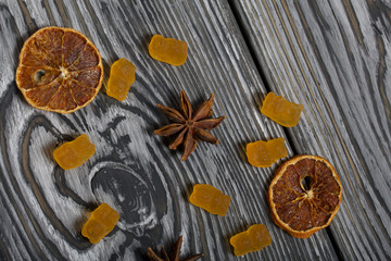 Jelly chewing sweets. Dried slices of orange and anise stars. Scattered on brushed pine boards painted in black and white.