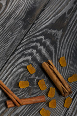 Jelly chewing sweets and cinnamon sticks. Scattered on brushed pine boards painted in black and white.