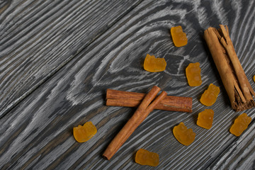 Jelly chewing sweets and cinnamon sticks. Scattered on brushed pine boards painted in black and white.