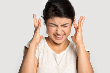 Irritated stressed millennial indian woman can't stand noise.